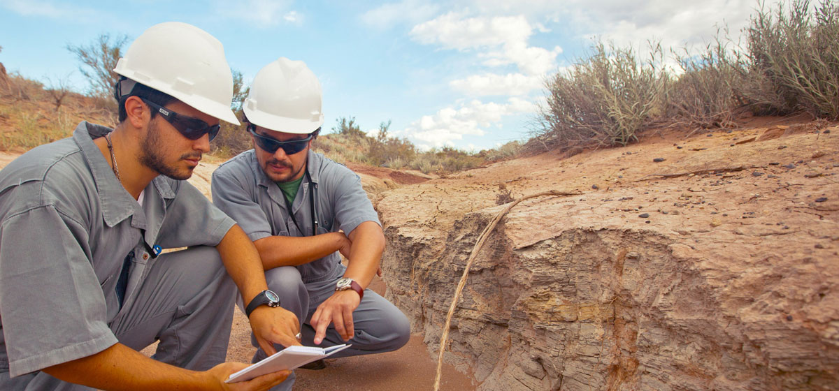 two workers looking in the ground