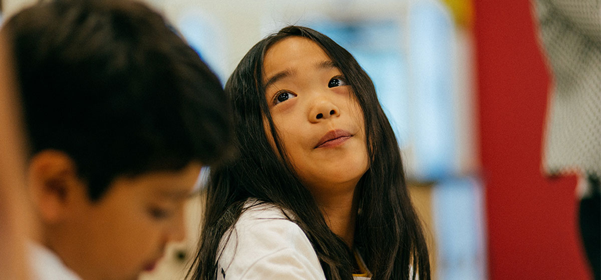 Child in a classroom looking up