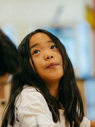 Child in a classroom looking up